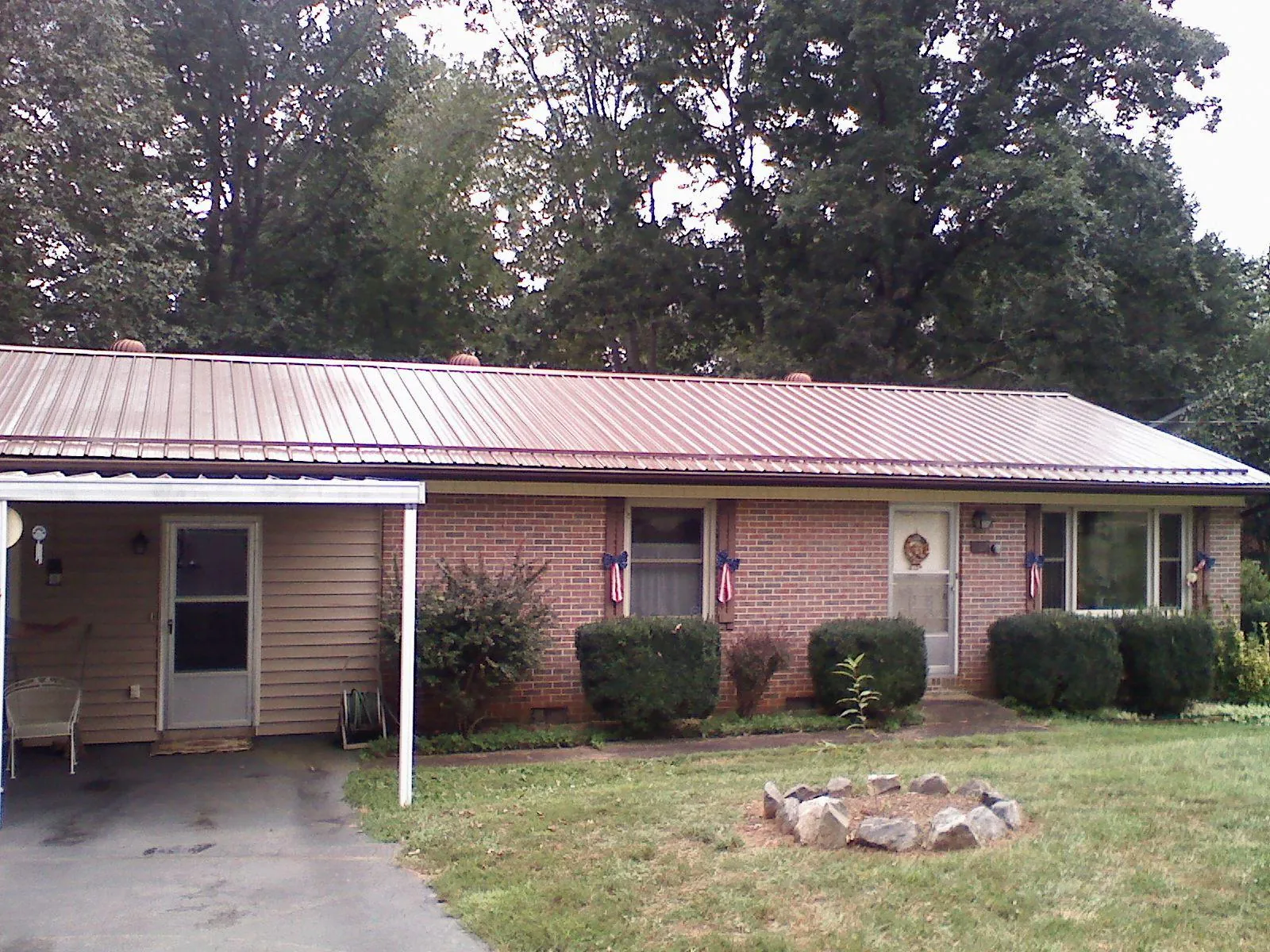 Bronze metal roof and carport on a brick ranch home — Roof Repair work by our crew in Loretto